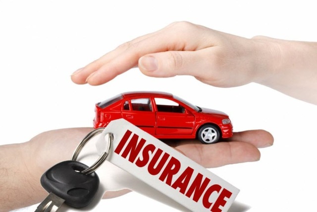 Hands protecting a red toy car with keys and insurance tag, symbolizing auto insurance coverage and security.