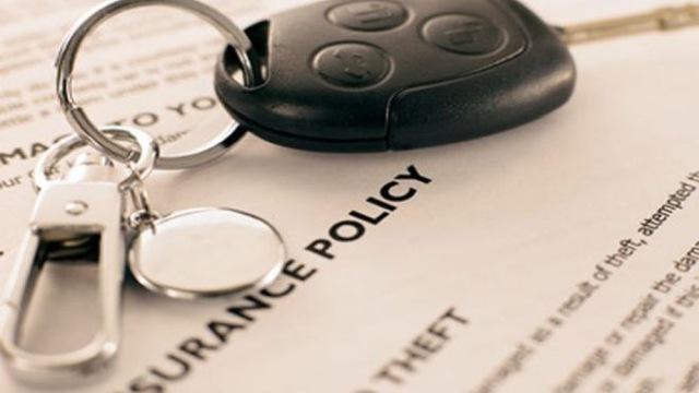 Car keys resting on a vehicle insurance policy document, symbolizing auto insurance coverage and security.