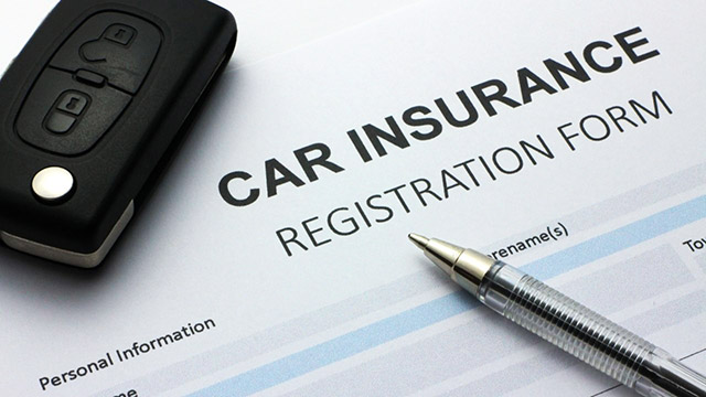 Car insurance registration form with pen and car key, indicating vehicle coverage application essentials.