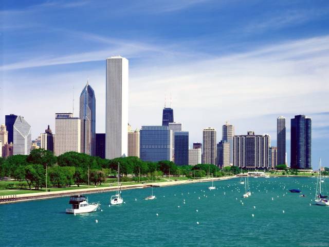 Chicago skyline with Lake Michigan, featuring modern skyscrapers and boats on a sunny day.