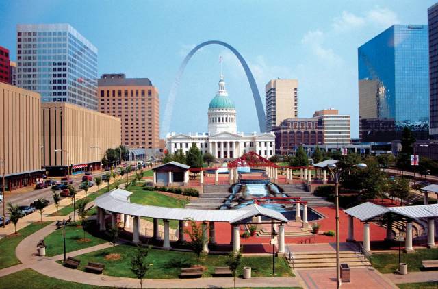 St. Louis skyline featuring the Gateway Arch and Old Courthouse with surrounding buildings and park in the foreground.