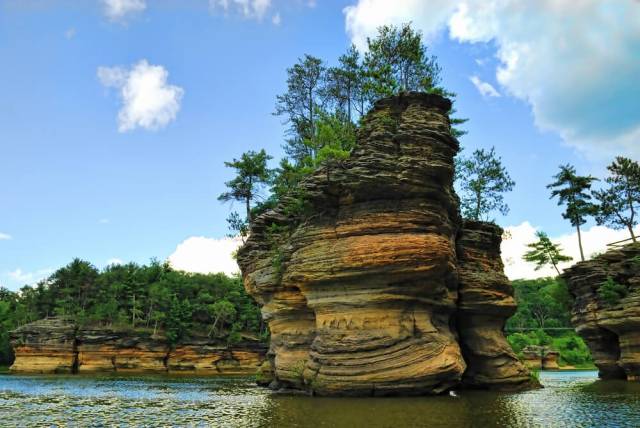 Scenic sandstone rock formation with trees at Wisconsin Dells under a blue sky.